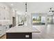 Modern kitchen with white cabinets and a black kitchen island with quartz countertops and stainless appliances at 4480 Beechnut Cir, Cumming, GA 30028