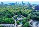 Aerial view of a neighborhood featuring community amenities, lush greenery, and a city skyline in the background at 29 Ivy Ne Trl, Atlanta, GA 30342