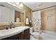 Bathroom featuring a dark vanity, decorative mirror, and a shower with neutral tile and a floral curtain at 29 Ivy Ne Trl, Atlanta, GA 30342