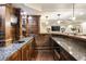 Basement wet bar featuring granite countertops, wood cabinets, and sink with stylish fixtures at 832 Forest Path Ln, Alpharetta, GA 30022