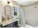 Modern bathroom with a granite countertop vanity, framed mirror, window, and shower and tub at 832 Forest Path Ln, Alpharetta, GA 30022