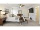 Spacious bedroom with a ceiling fan, mounted television, sitting area, and en-suite bathroom at 832 Forest Path Ln, Alpharetta, GA 30022