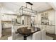 Open-concept dining area with modern light fixture seamlessly connected to kitchen and living room at 832 Forest Path Ln, Alpharetta, GA 30022