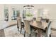 Elegant dining room with rustic wood table, modern chandelier, and views of the outdoor living space at 832 Forest Path Ln, Alpharetta, GA 30022