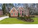 Charming two-story brick home with manicured lawn, mature trees, and beautiful landscaping at 832 Forest Path Ln, Alpharetta, GA 30022