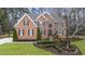 Charming brick home with manicured landscaping, symmetrical facade, and well-maintained lawn at 832 Forest Path Ln, Alpharetta, GA 30022