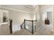 Hallway with a view of the foyer features a modern light fixture, wood trim, and carpeted floors at 832 Forest Path Ln, Alpharetta, GA 30022