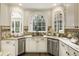 Bright kitchen featuring granite counters, custom cabinets, stainless appliances, and arched windows at 832 Forest Path Ln, Alpharetta, GA 30022