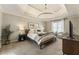 Bright main bedroom with tray ceilings, a large window, and a seating area at 832 Forest Path Ln, Alpharetta, GA 30022