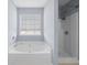 Bathroom with a large soaking tub under a window and a separate shower at 2010 Skylar Leigh Dr, Buford, GA 30518
