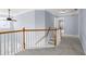 Upstairs hallway boasts plush carpeting, wood-paneled banisters, and neutral paint at 2010 Skylar Leigh Dr, Buford, GA 30518