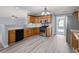 Kitchen with stainless appliances, wood cabinets, laminate floors, and an open view to the living room at 2010 Skylar Leigh Dr, Buford, GA 30518