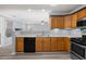 Open-concept kitchen features stainless appliances, double sink, wood cabinets, and a view to the living area at 2010 Skylar Leigh Dr, Buford, GA 30518