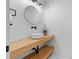 Bright half-bathroom with floating wood sink, a round mirror, and matte black hardware at 2949 Summitop Ne Ct, Marietta, GA 30066