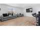 Modern living room with light wood floors, two gray sofas, large window, and a wall-mounted television at 2949 Summitop Ne Ct, Marietta, GA 30066