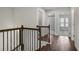 Bright hallway featuring hardwood floors, a dark railing staircase, and multiple entryways at 3533 Koyla Lndg # 5, Chamblee, GA 30341