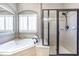 Bright bathroom featuring a soaking tub, a separate shower, and plantation shutters at 4815 Westgate Dr, Cumming, GA 30040