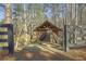 Picturesque covered bridge leading to a pond, surrounded by lush trees, creating a serene outdoor escape at 4815 Westgate Dr, Cumming, GA 30040