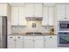 Well-equipped kitchen with white cabinets, stainless steel appliances, granite countertops, and tile backsplash at 4815 Westgate Dr, Cumming, GA 30040