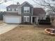 Inviting home featuring stone accents, a two-car garage, and mature landscaping at 1631 Royal Ives Dr, Lawrenceville, GA 30045