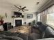 Relaxing living room with a fireplace, ceiling fan, large sectional sofa, and natural light at 1631 Royal Ives Dr, Lawrenceville, GA 30045