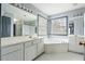 Bathroom with a large mirror, double sinks, soaking tub, and natural light at 1021 Adah Ln, Lawrenceville, GA 30043