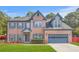 Charming two-story brick home with blue shutters, attached garage, and well-manicured lawn at 1021 Adah Ln, Lawrenceville, GA 30043