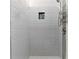 Close-up of a tiled shower with a shower head and built-in shelving for storage at 1021 Adah Ln, Lawrenceville, GA 30043