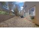 View of the backyard with a retaining wall and a beige siding house under a partly cloudy sky at 3624 Bancroft Main Nw, Kennesaw, GA 30144