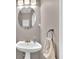 Cozy powder room with pedestal sink, brushed nickel hardware and decorative mirror at 3624 Bancroft Main Nw, Kennesaw, GA 30144