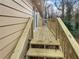 Newly constructed backyard deck features wooden steps with scenic wooded views, offering outdoor enjoyment at 4726 Alpine Sw Dr, Lilburn, GA 30047