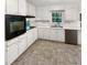 Clean kitchen featuring white cabinets, an electric range, and stainless steel dishwasher at 4726 Alpine Sw Dr, Lilburn, GA 30047