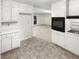 A kitchen featuring white cabinets, appliances, and an open layout leading to the living area at 4726 Alpine Sw Dr, Lilburn, GA 30047