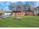 Expansive backyard with lush green lawn, mature trees, and brick home exterior at 103 Timberlane Rd, Cumming, GA 30040