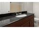 A bathroom vanity with a dark countertop, a sink with shiny fixtures, and a mirrored backsplash at 3284 Devaughn Ne Dr, Marietta, GA 30066