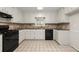 Traditional kitchen with white cabinetry, black appliances, and tiled floor at 3284 Devaughn Ne Dr, Marietta, GA 30066