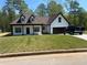 Charming new construction home with a manicured lawn, modern white siding and black trim at 200 Brookwood Xing, Douglasville, GA 30134