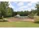 Community tennis court is adjacent to the neighborhood pool and is surrounded by mature trees and manicured landscaping at 200 Brookwood Xing, Douglasville, GA 30134