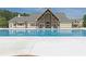 Community pool with a covered veranda featuring a stone fireplace and outdoor seating at 242 Crestbrook Ln, Dallas, GA 30157