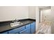 Functional laundry area with blue cabinetry, stainless steel sink, and organized shelving for added storage at 5111 Olde Mill Ne Dr, Woodstock, GA 30188