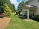 View of backyard with stone patio, outdoor furniture, and lush green landscaping at 200 Edinburgh Ln, Woodstock, GA 30188