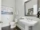 Elegant powder room features a pedestal sink, decorative mirror, and sailboat art at 200 Edinburgh Ln, Woodstock, GA 30188
