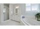 Bright white bathroom features a walk-in shower, soaking tub, vanity and shuttered windows at 200 Edinburgh Ln, Woodstock, GA 30188