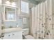 Bathroom featuring single sink vanity, toilet and shower behind a floral curtain at 200 Edinburgh Ln, Woodstock, GA 30188