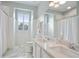 Bright bathroom featuring dual sinks, marble flooring, and a shower/tub combo at 200 Edinburgh Ln, Woodstock, GA 30188