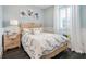 Bedroom with blue walls, wood floors, paisley bedding, a side table and window at 200 Edinburgh Ln, Woodstock, GA 30188