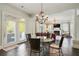 Open floor plan of dining room and living room featuring hardwood floors, fireplace, and chandeliers at 200 Edinburgh Ln, Woodstock, GA 30188