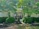 Exterior of home reveals back patio with outdoor dining, chairs, and landscaping at 200 Edinburgh Ln, Woodstock, GA 30188
