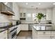 Modern kitchen with island, stainless steel appliances, and ample cabinet space at 200 Edinburgh Ln, Woodstock, GA 30188