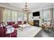 Open living room boasts fireplace, large windows and doors, and a sleek chandelier at 200 Edinburgh Ln, Woodstock, GA 30188